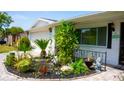 Close up on a cozy front yard with lush greenery, a paver walkway, and a charming statue at 7321 San Moritz Dr, Port Richey, FL 34668