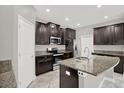Modern kitchen featuring granite countertops, stainless steel appliances, and dark wood cabinetry at 7336 Bagley Cove Ct, Sun City Center, FL 33573