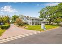 Elegant two-story home featuring a brick driveway, manicured lawn, and a charming exterior at 7352 Hunt Club Ln, Seminole, FL 33776
