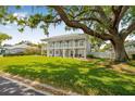Charming two-story home with a spacious front yard and beautiful mature tree shading the property at 7352 Hunt Club Ln, Seminole, FL 33776