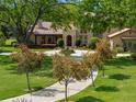 Inviting home with a circular driveway, manicured lawn, and mature trees, showcasing a serene landscape at 7775 Still Lakes Dr, Odessa, FL 33556