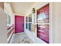Welcoming front porch with a bright raspberry door, charming light fixture, and window at 7802 Hardwick Dr # 1126, New Port Richey, FL 34653
