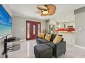 Inviting living room with new marble floors, stylish ceiling fan, and open layout leading into the modern kitchen at 8408 Flagstone Dr, Tampa, FL 33615