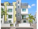 Modern townhome showcasing a stylish facade, balcony, and a gated entrance for added privacy and security at 907 Arlington N Ave, St Petersburg, FL 33705