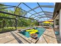 Inviting screened-in pool area with a yellow raft, spa, and lush green surroundings at 10505 Inglenook Ter, Palmetto, FL 34221