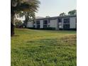 Well-maintained condo building surrounded by a lush green lawn showcasing the community's landscape at 113 Nina Way # 113, Oldsmar, FL 34677