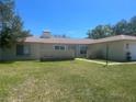 Residential home featuring large green front lawn, updated windows, and tan painted exterior at 11708 Nicklaus Cir, Tampa, FL 33624