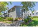 Attractive condo complex with mature landscaping, grey siding, stairs to the units, and a charming, welcoming appeal at 11868 Skylake Pl # 11767, Temple Terrace, FL 33617