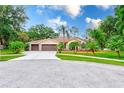 Traditional home boasts a three car garage, meticulous landscaping, and a circular driveway at 12302 Knight Pl, Thonotosassa, FL 33592