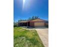 Welcoming brick home with a well-maintained lawn, attached garage, and long driveway at 1850 Oklahoma Ne Ave, St Petersburg, FL 33703
