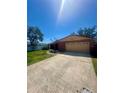 Brick home boasting an attached garage, driveway, and a spacious green lawn at 1850 Oklahoma Ne Ave, St Petersburg, FL 33703
