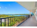 Long outdoor balcony with iron railing overlooking foliage and waterway, adjacent to the condo hallway at 19531 Gulf Blvd # 404, Indian Shores, FL 33785