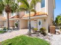Charming condo exterior with a vibrant orange tile roof, manicured landscaping, and a private garage at 200 Brightwater Dr # 10, Clearwater Beach, FL 33767