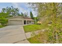Inviting single-Gathering home with a well-maintained lawn and an attached two-car garage at 2812 Ormandy Ct, Tampa, FL 33618