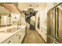 A chef's kitchen with white cabinetry, stainless appliances, concrete flooring, and spiral staircase at 35150 Roth Ln, Dade City, FL 33525