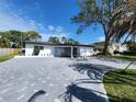 Charming single-story home with a paved driveway and well-maintained landscaping under a blue sky at 4619 Helena Ne St, St Petersburg, FL 33703