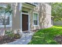 Exterior view of the front door of a townhome with a sidewalk and landscaping at 4920 Pond Ridge Dr, Riverview, FL 33578