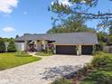 Attractive home featuring a lush front yard, brick driveway, and a two-car garage at 506 Crystal Grove Blvd, Lutz, FL 33548