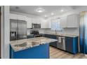 Modern kitchen with granite countertops, stainless steel appliances, and blue and white cabinetry at 5413 N Park Pl, Tampa, FL 33603