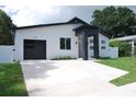 Modern home features clean lines, minimalist landscaping, and a black garage door for striking curb appeal at 5518 Newton S Ave, Gulfport, FL 33707