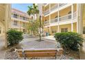 An inner courtyard featuring a stone walkway and bench at a condominium complex at 701 Mirror Lake N Dr # 119, St Petersburg, FL 33701