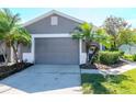 Two car garage door with lush landscaping and front yard at 7441 Trovita Rd, Land O Lakes, FL 34637