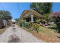 Charming home exterior with a spacious yard, lush landscaping, and a long driveway leading to the back at 910 E North Bay St, Tampa, FL 33603