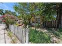 Quaint home with a picket fence and mature trees offering shade and privacy in the front yard at 910 E North Bay St, Tampa, FL 33603