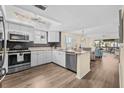 Bright kitchen with white cabinets, stainless steel appliances, and granite countertops at 911 Harbour House Dr, Indian Rocks Beach, FL 33785