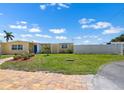 Yellow home with a blue front door and well-manicured lawn and landscape at 109 Carmelina St, Ruskin, FL 33570
