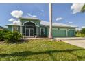 Inviting single-story home with a three-car garage, lush lawn, and charming screened entryway at 1161 Rio De Janeiro Ave, Punta Gorda, FL 33983