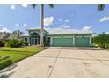 Bright, inviting single-story home with a three-car garage, set against a backdrop of blue skies and green lawn at 1161 Rio De Janeiro Ave, Punta Gorda, FL 33983
