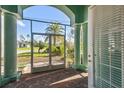 View of a screened-in front porch with brick flooring and wrought iron gates, offering a glimpse of the outdoors at 1161 Rio De Janeiro Ave, Punta Gorda, FL 33983
