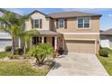 Inviting two-story home featuring a well-manicured lawn and an attached two-car garage at 11820 Sunburst Marble Rd, Riverview, FL 33579