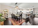Open-concept dining area with hardwood floors, modern lighting fixture, and adjacent kitchen at 13110 Shumard Way, Riverview, FL 33579