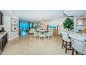 Open-concept dining area with a chandelier, views of the living area and ocean beyond at 1350 Gulf Blvd # 502, Clearwater Beach, FL 33767