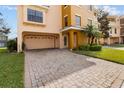 Long brick driveway that leads to a two-car garage, adjacent to manicured lawn with palm trees at 1537 Ember Ln, Tarpon Springs, FL 34689