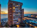 A striking view of a high-rise beachfront condo tower at sunset showing its multiple floors at 17920 Gulf Blvd # 2004, Redington Shores, FL 33708