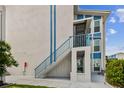 Side exterior with blue staircase leading to the condo door at 315 Medallion Blvd # E, Madeira Beach, FL 33708