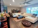 Spacious living room with a large sectional sofa, hardwood floors, and bright natural light at 3217 W Lawn Ave, Tampa, FL 33611
