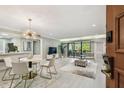 Open-concept living space featuring modern decor, light floors, and a sliding glass door to a balcony at 36750 Us 19 N # 20211, Palm Harbor, FL 34684