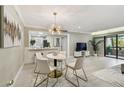 Bright living space with a modern dining table and light grey flooring leading to the balcony at 36750 Us 19 N # 20211, Palm Harbor, FL 34684