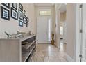 Inviting home foyer featuring neutral walls, tile floors, and a decorative shelf at 4839 Pointe O Woods Dr, Wesley Chapel, FL 33543