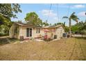 Relaxing backyard with patio set on concrete slab, surrounded by lush greenery, and features solar panels on home at 5050 68Th N Way, St Petersburg, FL 33709
