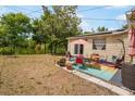 Inviting backyard patio area featuring an outdoor dining set, lush greenery, and relaxing lakeside views at 5050 68Th N Way, St Petersburg, FL 33709