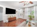 Bright living room with hardwood floors, a large TV, and an inviting front door at 5050 68Th N Way, St Petersburg, FL 33709