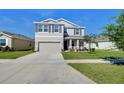 A charming two-story home with a well-manicured lawn, a two car garage, and delightful curb appeal at 5325 Thistle Field Ct, Wesley Chapel, FL 33545