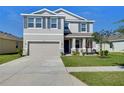 Charming two-story home featuring a well-kept lawn, two-car garage, and inviting curb appeal at 5325 Thistle Field Ct, Wesley Chapel, FL 33545