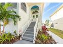 Home's front entrance with stairs, white railings, and lush landscaping at 6311 Bayside Dr, New Port Richey, FL 34652