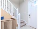 Inviting entryway features a staircase with white railings, neutral walls, and a storage cabinet at 6827 Citrus Creek Ln, Tampa, FL 33625